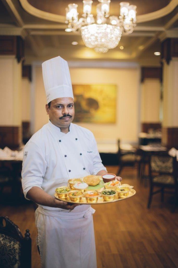 Taj Ganges Варанасі Екстер'єр фото A chef with a selection of Indian snacks